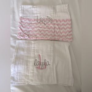 Two customized cotton burp cloths with “Layla” monogrammed on them